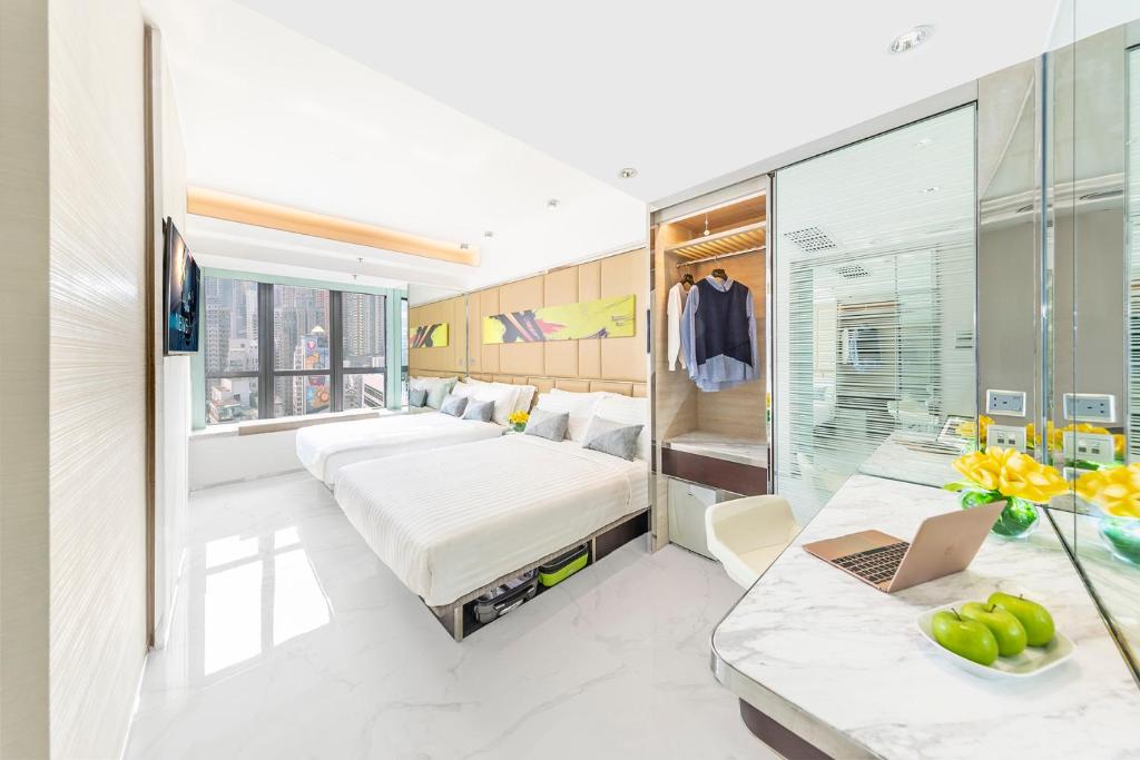 una camera d'albergo con letto e scrivania con computer portatile di iclub AMTD Sheung Wan Hotel a Hong Kong