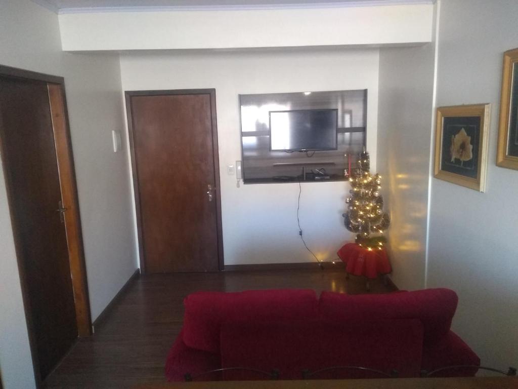 een woonkamer met een rode bank en een kerstboom bij Residencial Müller in Canela