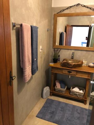 a bathroom with a sink and a mirror at Chalé de luxo pertinho de Monte Verde in Monte Verde