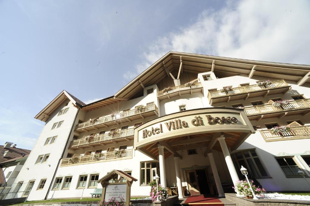 budynek hotelowy z napisem "Hotel Village chocobo" w obiekcie Aparthotel Wellness Villa di Bosco w mieście Tesero