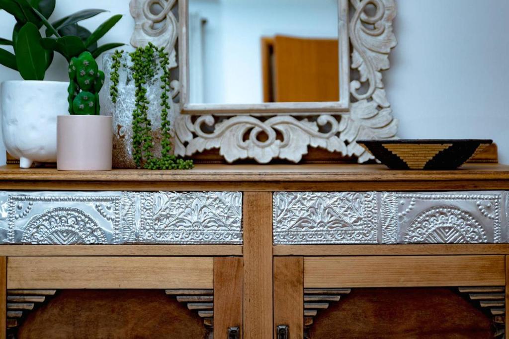 a mirror on top of a wooden table with plants at A Little Getaway in South West Rocks