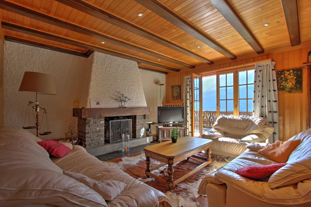 a living room with two couches and a fireplace at Les Chélettes in Chateau-d'Oex