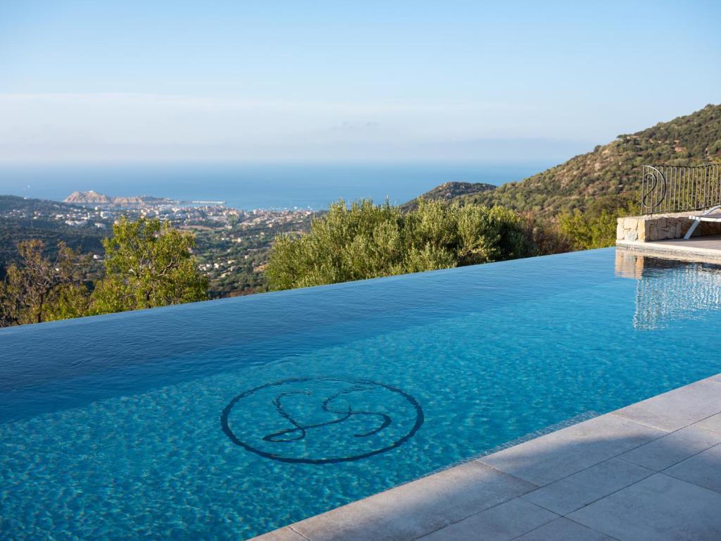 a infinity pool with a infinity symbol in the water at Hotel La Santa in Santa-Reparata-di-Balagna