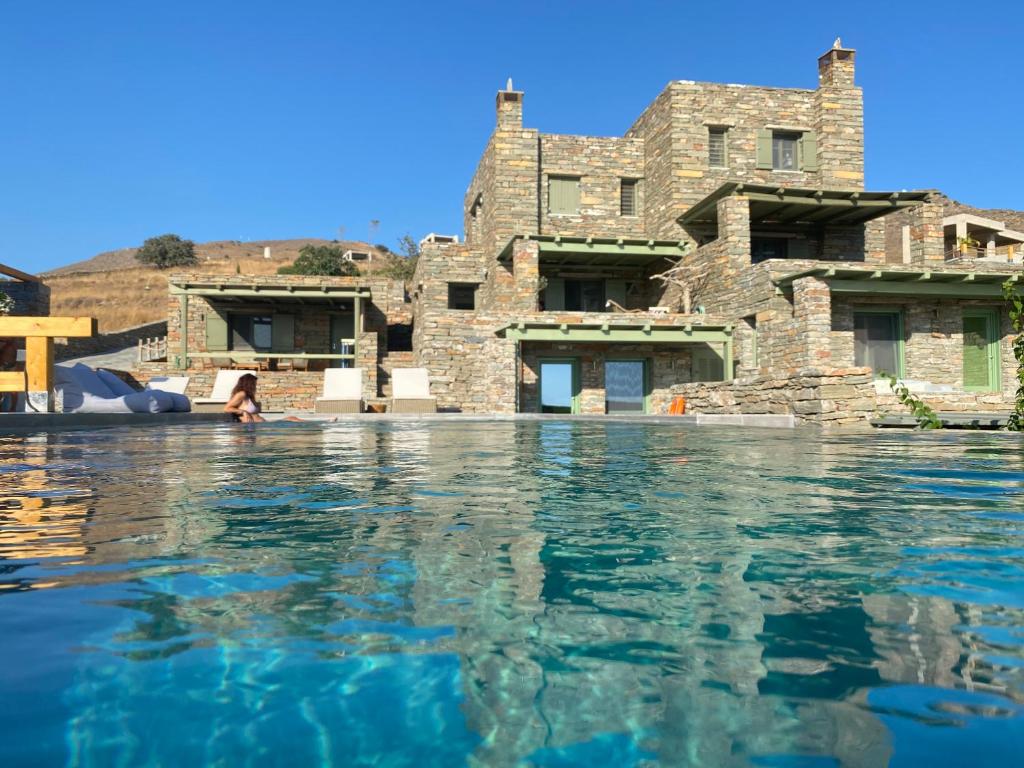 a house with a swimming pool in front of it at Sea & Stone Villas in Koundouros