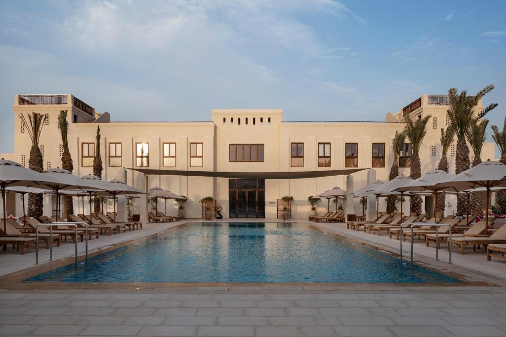 een hotel met een zwembad voor een gebouw bij Kedma by Isrotel Design in Sede Boqer