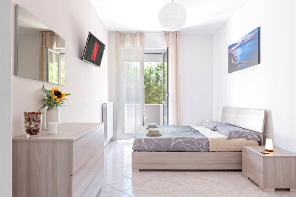een witte slaapkamer met een bed en een raam bij [FREE PARKING] Appartamento 5 STELLE elegante con suite in Livorno