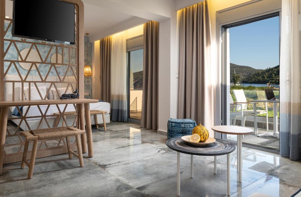a living room with a television and a room with a balcony at Notia Luxury Living in Porto Koufo