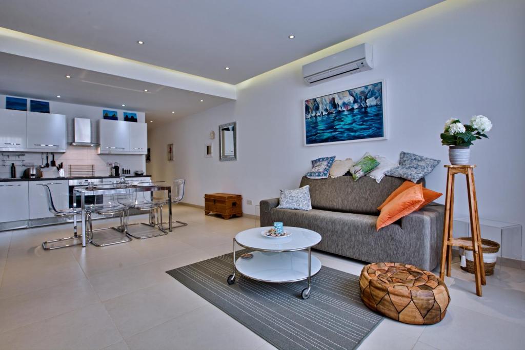 a living room with a couch and a kitchen at Bright and central 2 bedroom apartment in Sliema in Sliema