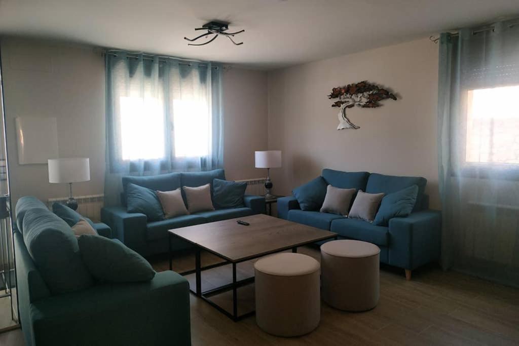 a living room with blue couches and a table at La Olma in Campillo de Aranda