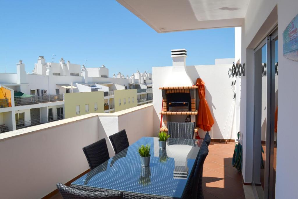 uma varanda com uma mesa e cadeiras num edifício em Clem Terrace Flat em Portimão