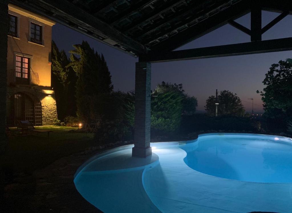 una piscina en un patio por la noche en SPINETO HOUSE, en Spineto Scrivia