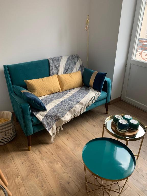 a living room with a green couch and a table at Studio en hyper centre - Wimereux in Wimereux
