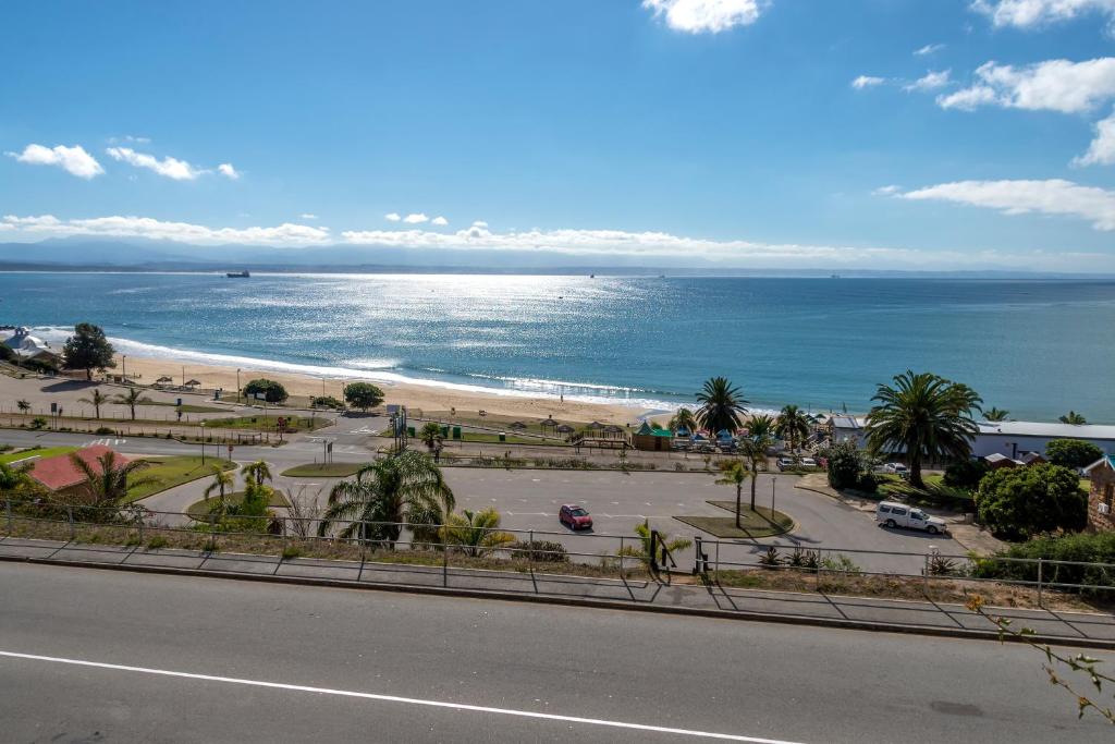 uma vista para a praia e para o oceano a partir de uma rua em The White House Apartment em Mossel Bay