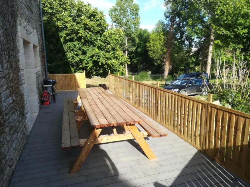 a wooden picnic table sitting on a deck at Maison familiale, 15couchages, de charme au cœur de la Bretagne - 20 min de Vannes in Lizio