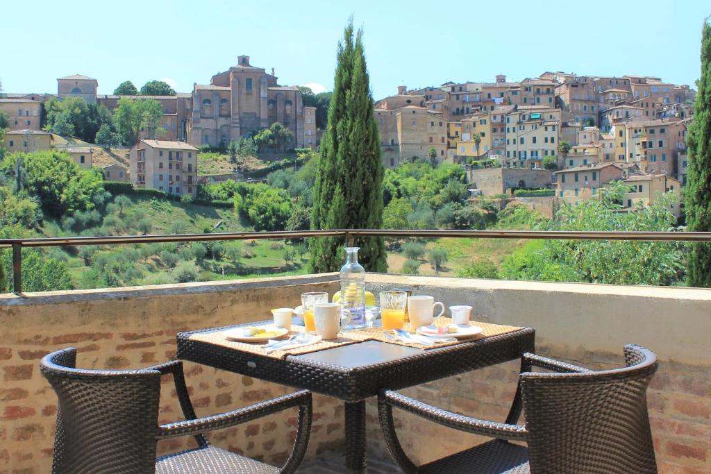 Villa del Sole Siena في سيينا: طاولة وكراسي على شرفة مطلة