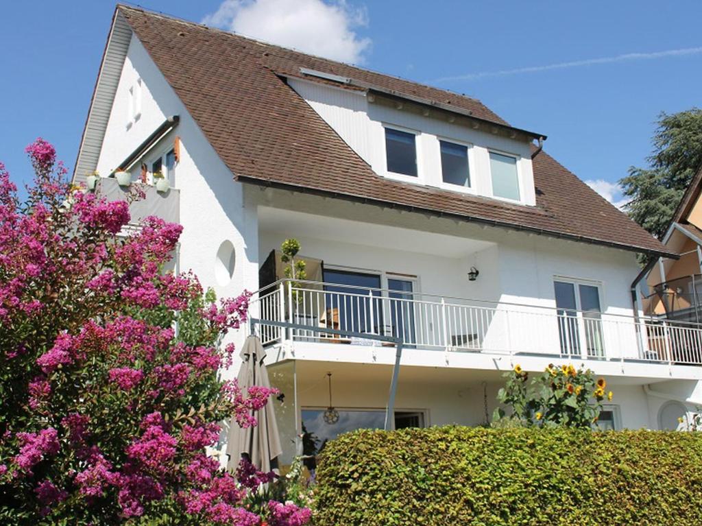 ヴァッサーブルクにあるHaus Amannの白い家(ピンクの花、バルコニー付)