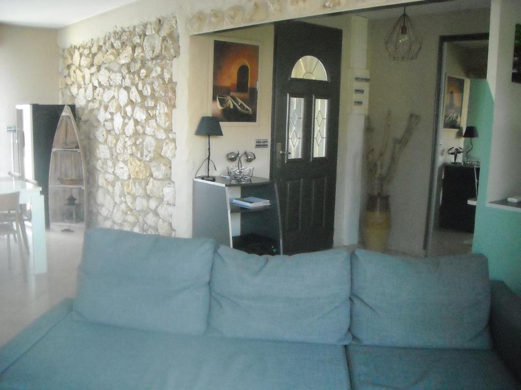 a living room with a blue couch and a door at PLEIN CENTRE GABARRET MAISON AVEC JARDIN in Gabarret