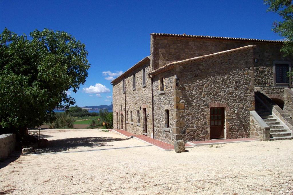 an old stone building with a tree next to it at Agriturismo Antica Cassia in Bolsena