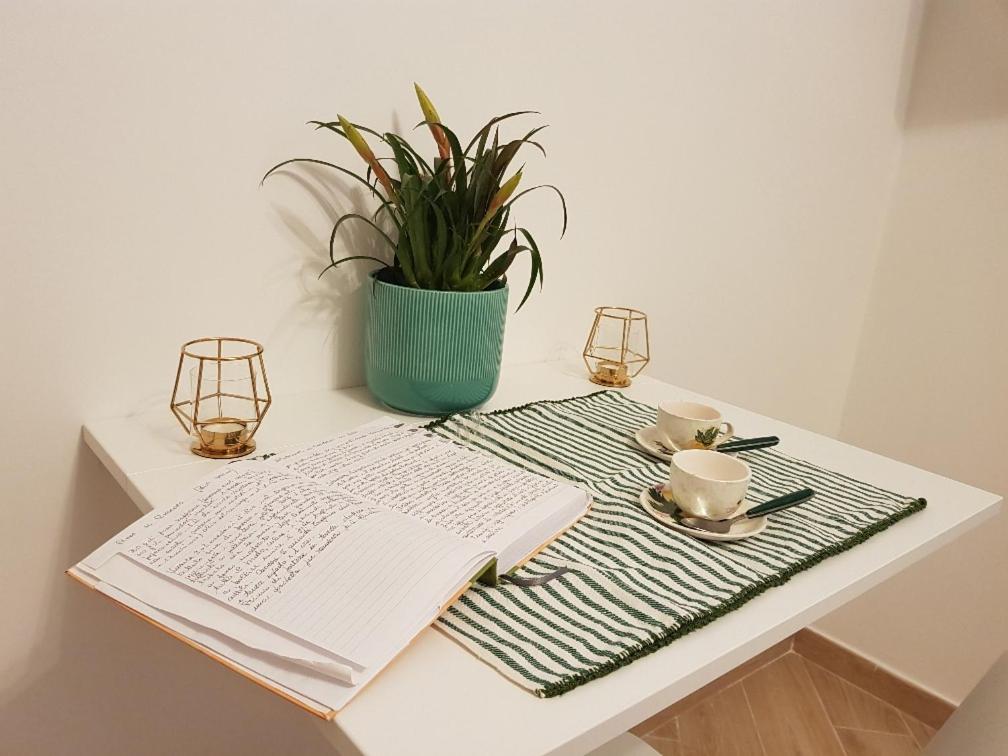uma mesa com um livro e uma chávena de café e uma planta em Edomus Roma em Roma