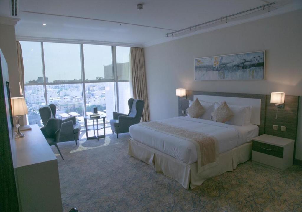 une chambre d'hôtel avec un lit, une table et des chaises dans l'établissement Hayat Al Riyadh Hotel, à Riyad