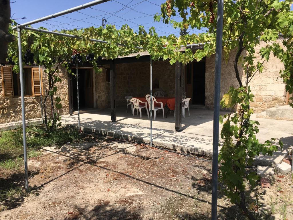 eine Terrasse mit einem Tisch und Stühlen unter einer Pergola in der Unterkunft Friendly villagehouse in Paphos City