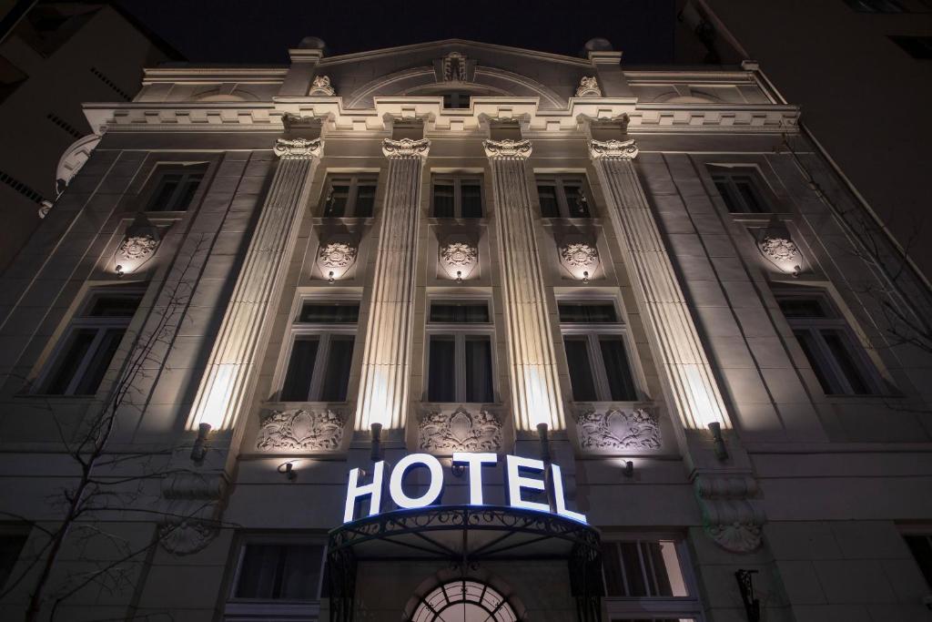 uma placa de hotel na frente de um edifício à noite em Public House Hotel em Belgrado