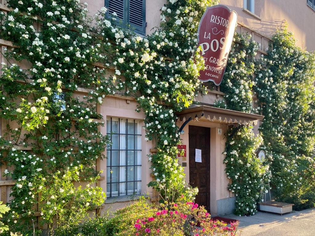 a building with flowers on the side of it at Locanda La Posta in Cavour