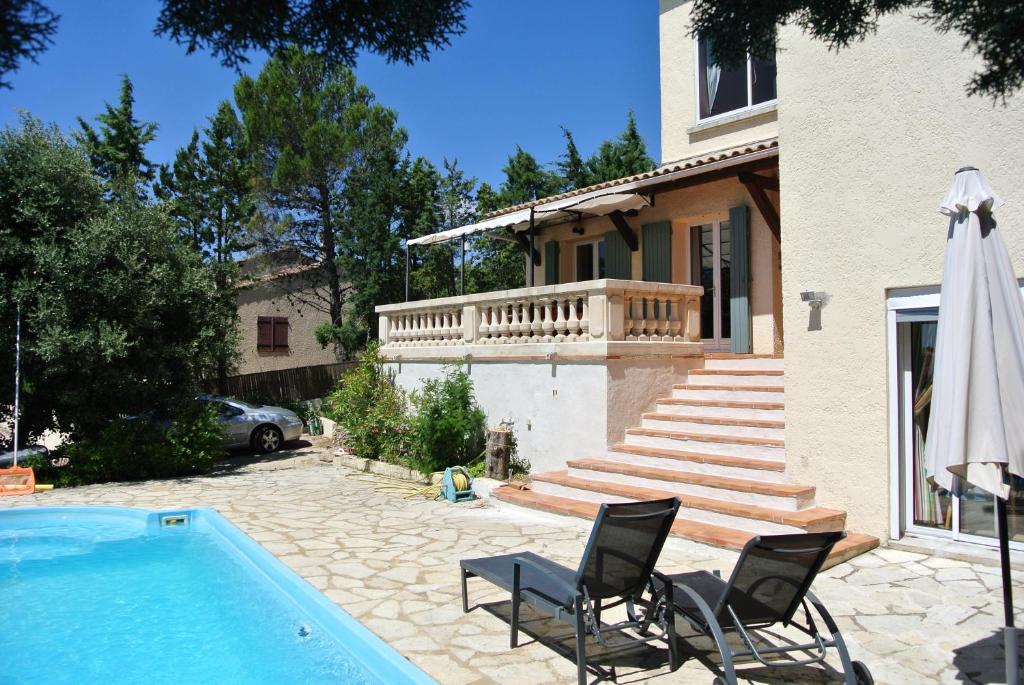 レ・アングルにあるEn Avignonのスイミングプールと椅子2脚付きの家