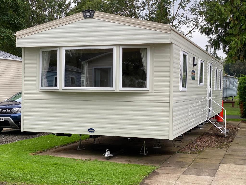 a white tiny house is parked in a yard at Haggerston Castle 6 Berth Caravan - Riverside 37 in Cheswick