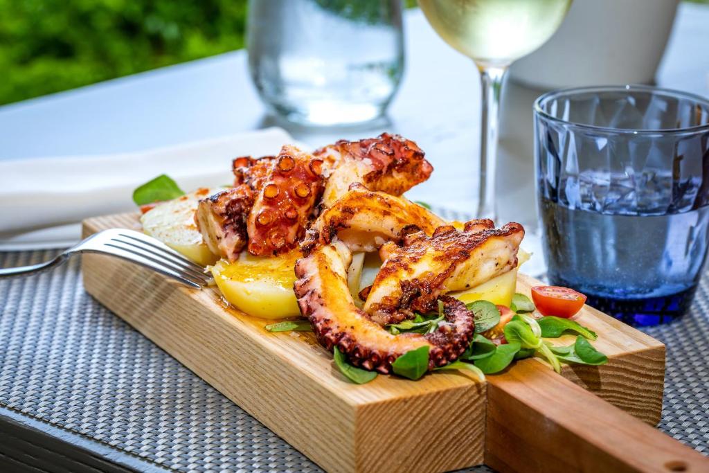 une assiette de nourriture avec des crevettes et des légumes sur une table dans l'établissement Hotel Llenaire, à Port de Pollença