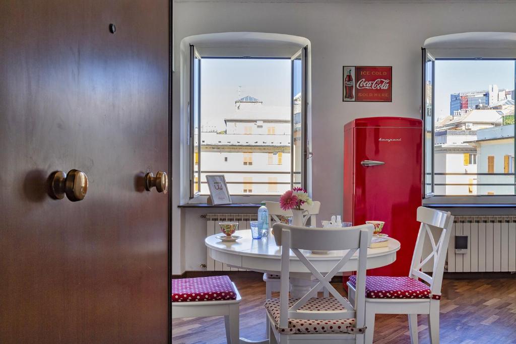 - une salle à manger avec une table et un réfrigérateur rouge dans l'établissement Colore e Stile nel centro di Genova by Wonderful Italy, à Gênes
