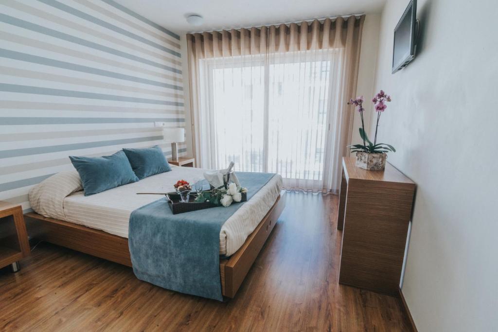 a bedroom with a bed and a large window at Hotel Nossa Senhora de Lurdes in Fátima