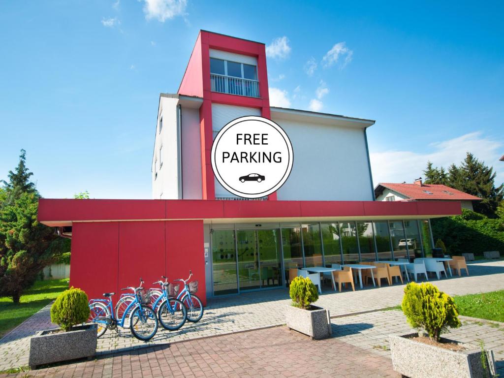 un edificio rojo con bicicletas estacionadas frente a él en Simbol Rooms with free private parking en Liubliana