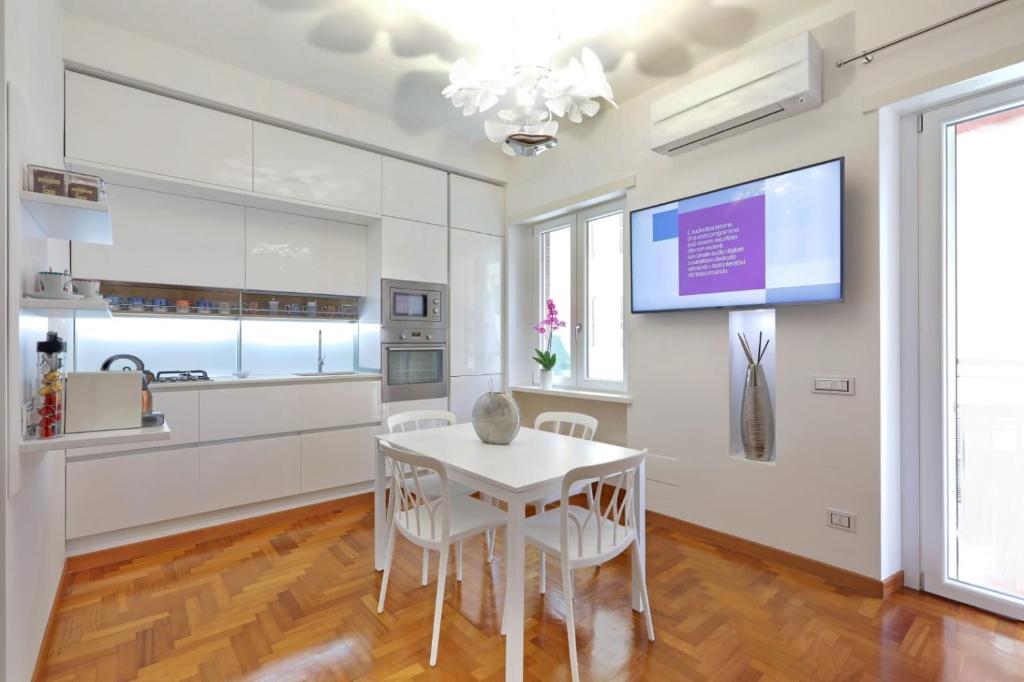 a kitchen with a white table and chairs and a tv at La Roma di Cecilia in Rome