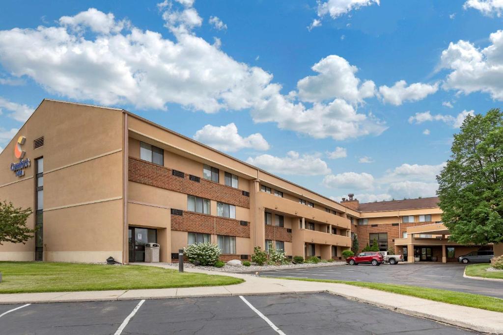 an image of a hotel with a parking lot at Comfort Inn in Lansing