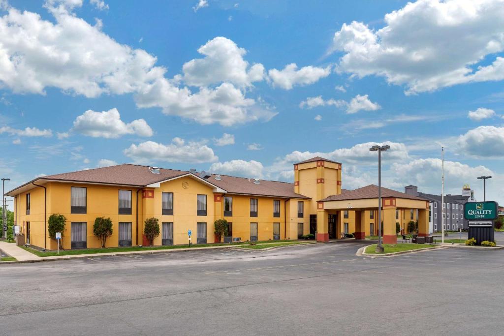 a large yellow building on a street with a parking lot at Quality Inn St Robert - Ft Leonard Wood in Saint Robert