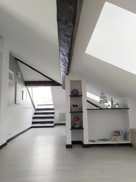 a white room with stairs and a stair case at La mansarda sul Porto in Camogli