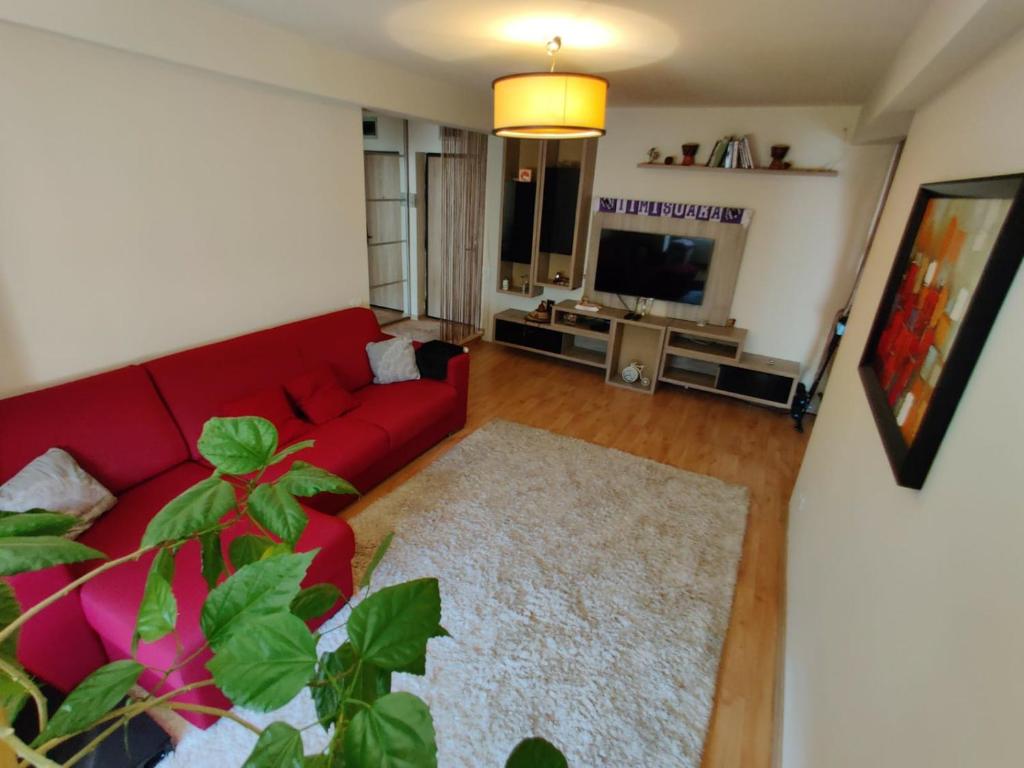 a living room with a red couch and a television at Lucky Home Timisoara 1 in Timişoara