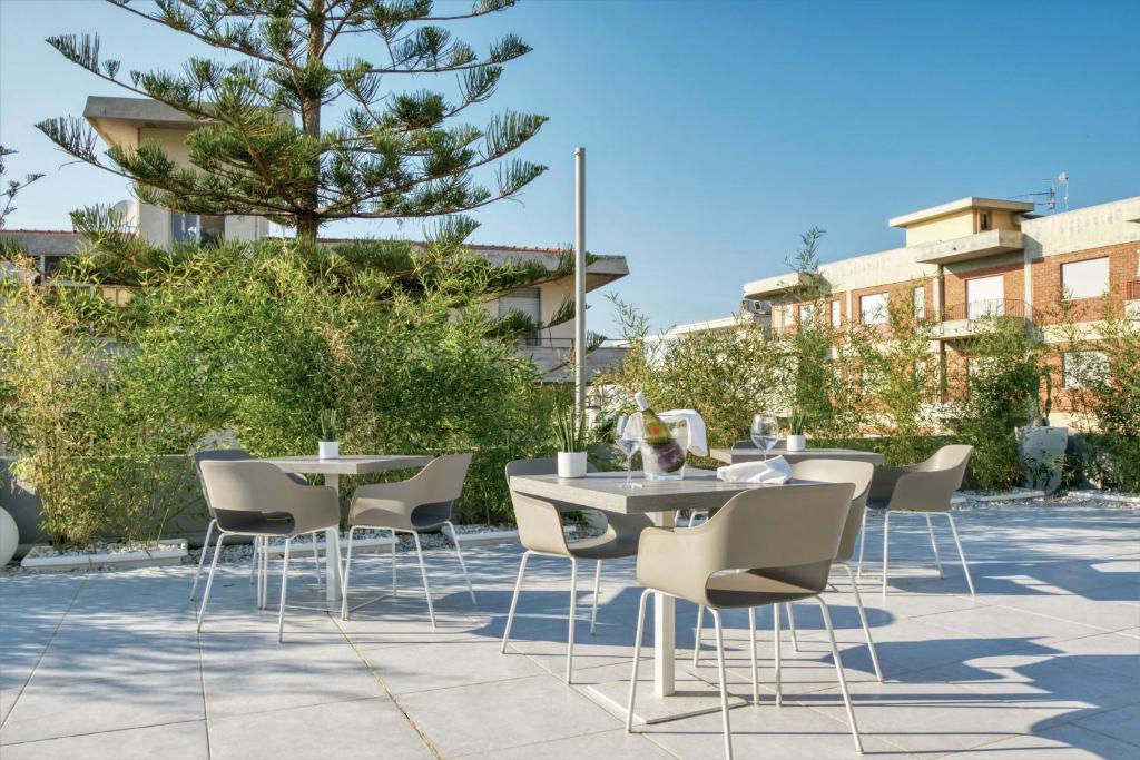 - un ensemble de tables et de chaises sur une terrasse dans l'établissement Horizon Suites, à Cefalù