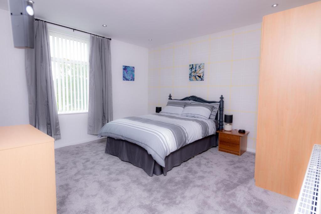 a bedroom with a bed and a large window at Entire House - 2 Bedroom - 3 Bed - Free wifi - TV in Clayton le Moors