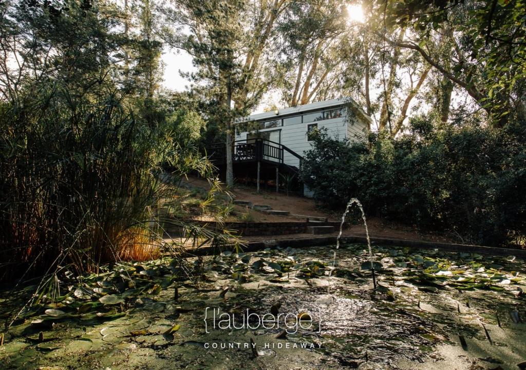 un remolque blanco en medio de un bosque en L'auberge Country Hideaway, en Port Elizabeth