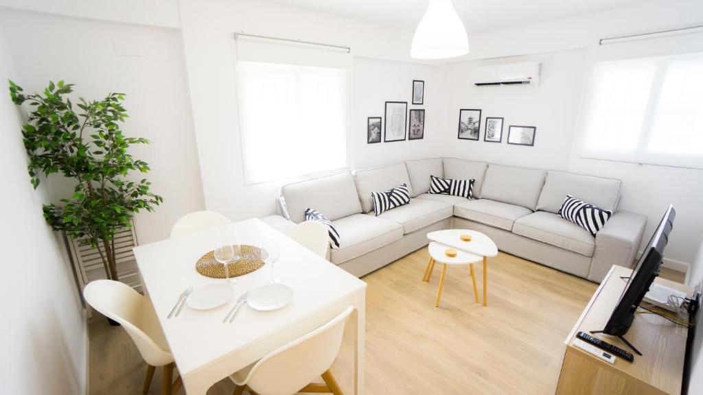 sala de estar con sofá blanco y mesa en RentalSevilla Elegante y luminoso apartamento en Triana, en Sevilla