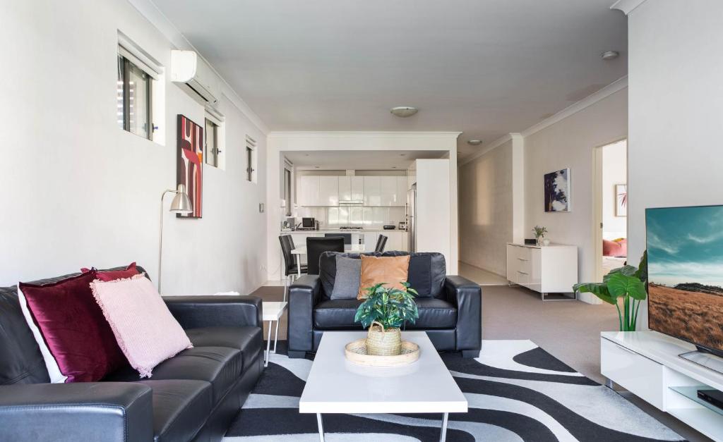 a living room with two couches and a table at Spacious Two-Bedroom Apartment near Hospital DUPLICATE in Sydney