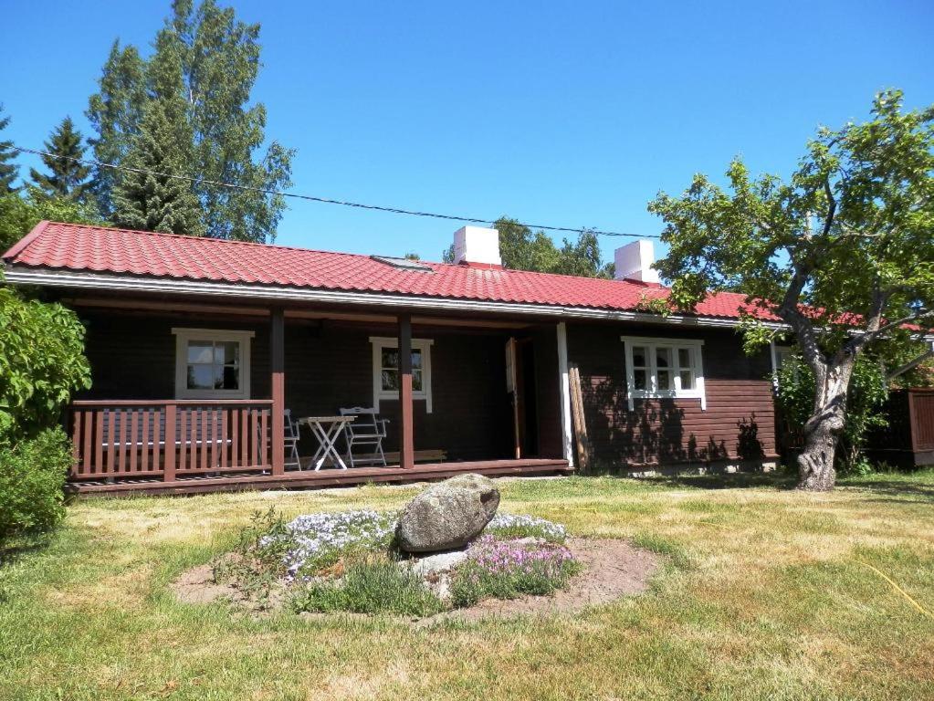 una casa con una gran roca delante de ella en Joosti Summer House en Käsmu