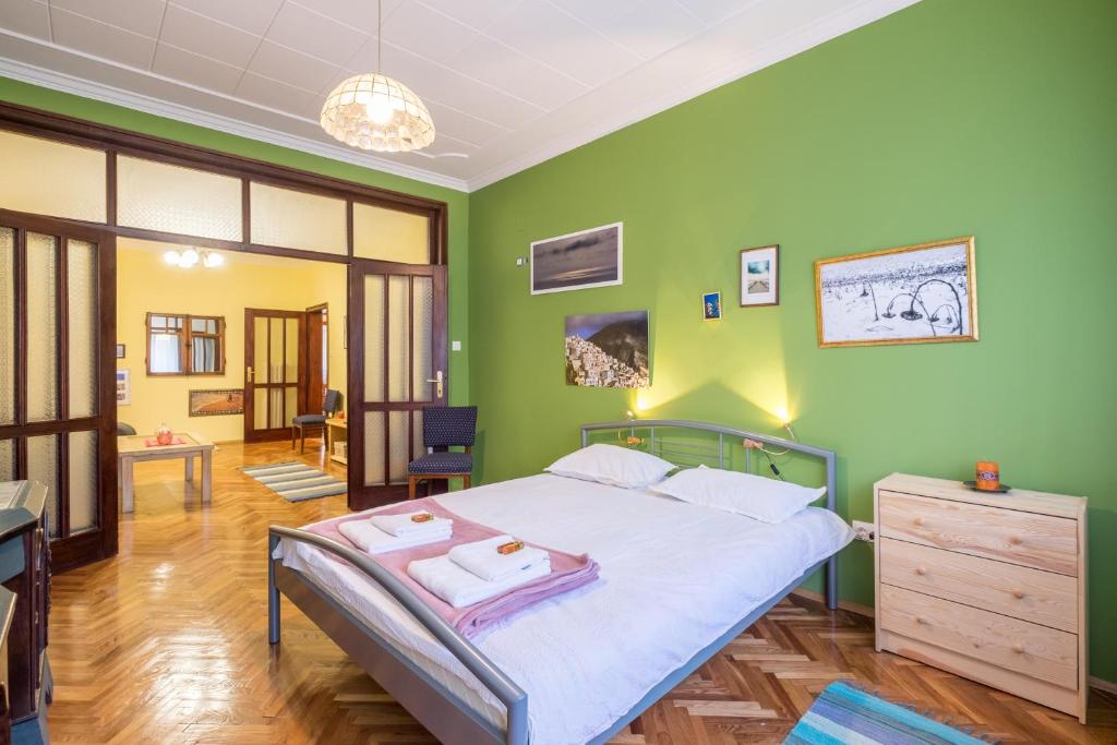- une chambre avec un lit et un mur vert dans l'établissement PhotoHome - Aristocratic Center of Sofia, à Sofia