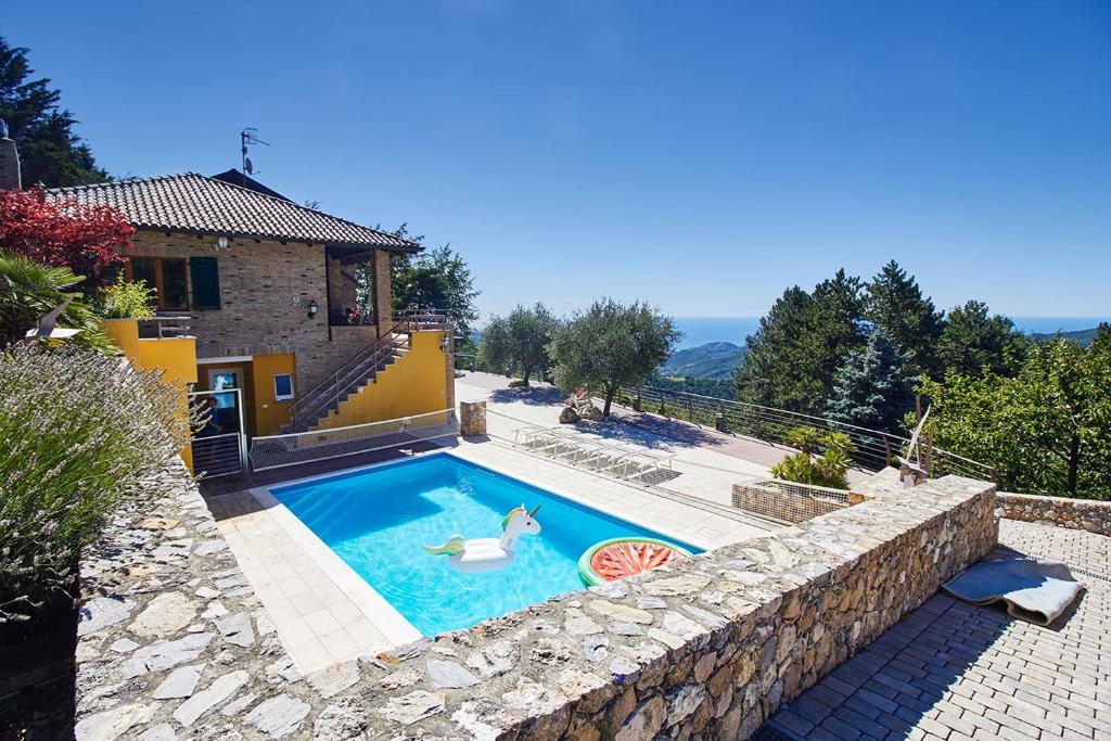 a swimming pool in front of a house at Villa Pina in Magliolo