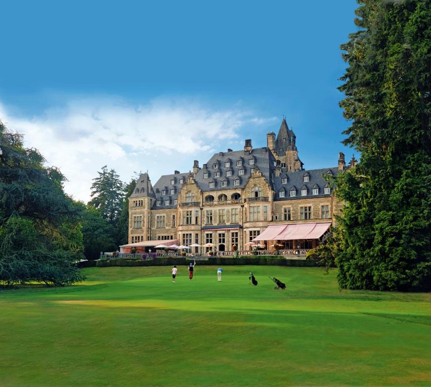 een groot gebouw met mensen ervoor bij Schlosshotel Kronberg - Hotel Frankfurt in Kronberg im Taunus