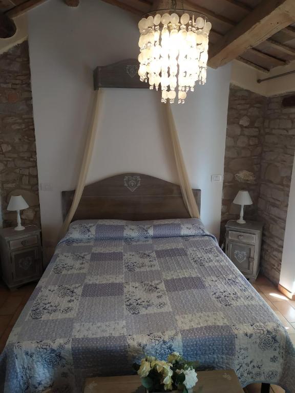 a bedroom with a bed and a chandelier at Fra Bosco e Cielo B&B in Mercato Saraceno