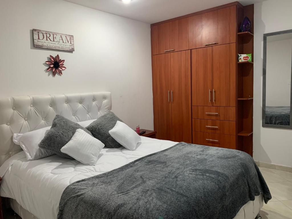 1 dormitorio con 1 cama grande y armario de madera en Hermoso apartamento con parqueadero en Fusagasuga