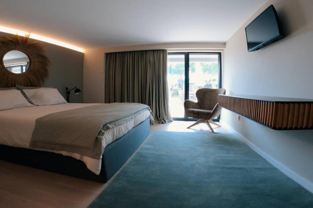 een hotelkamer met een bed en een stoel bij Casa da fonte in Apúlia